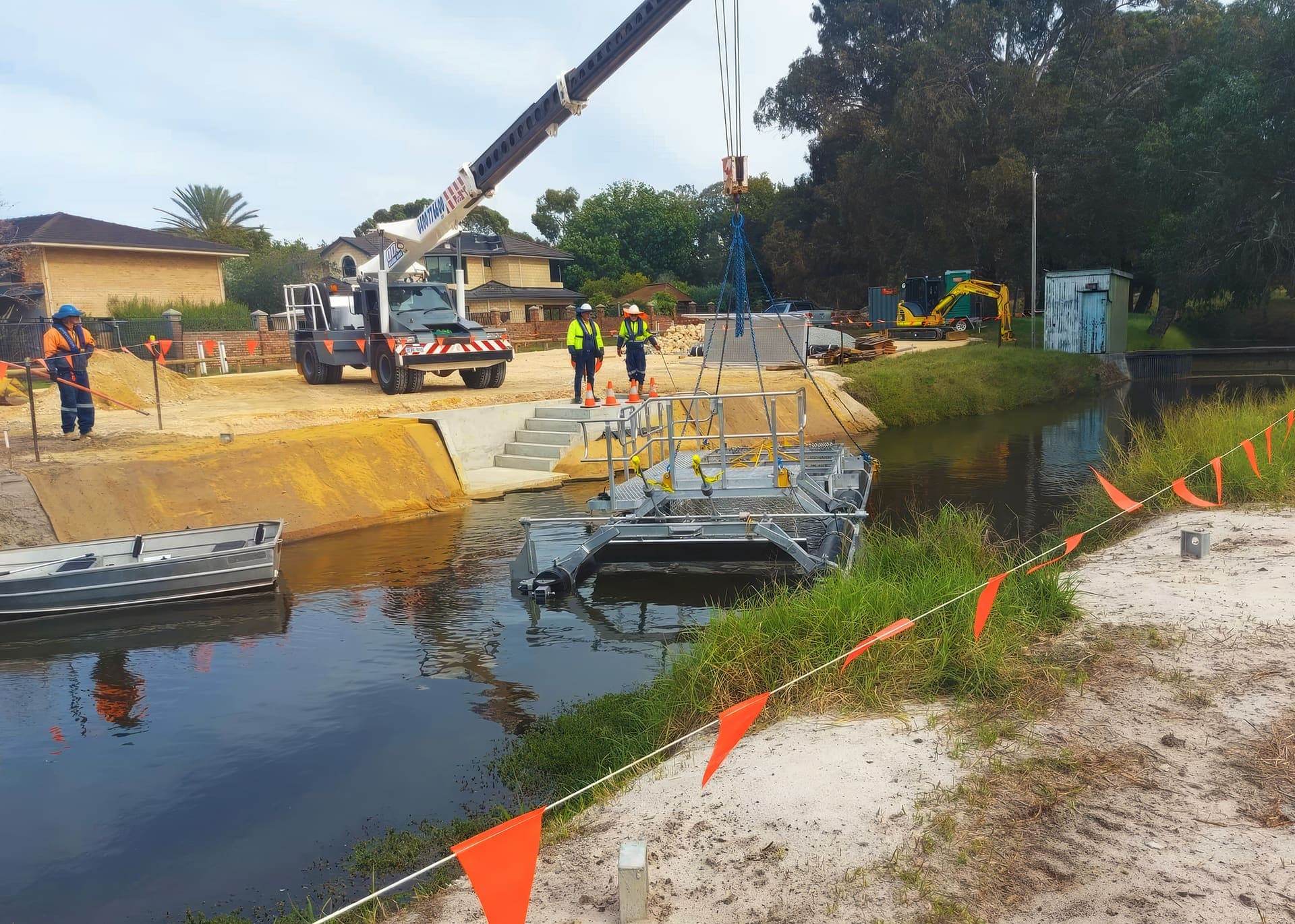 Litter boom and access platform positioned in the drain beside the new concrete headwall