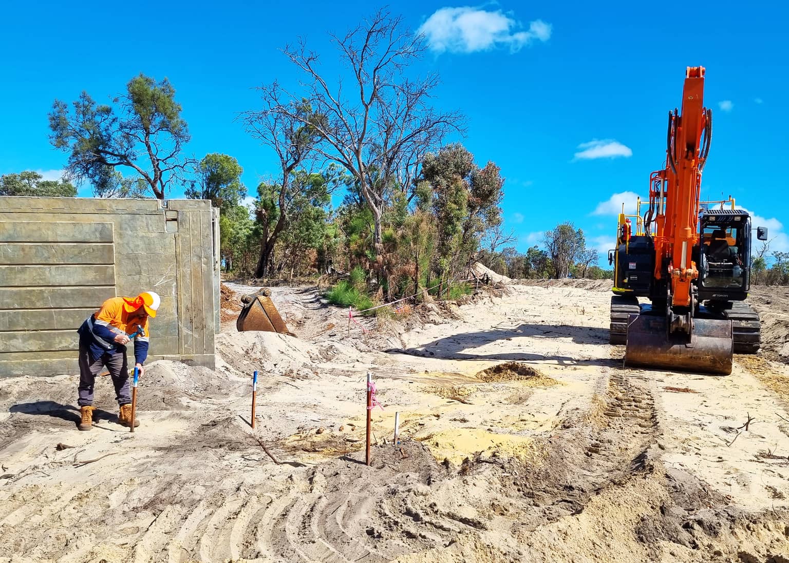 Excavator and crew on the cleared greenfield section at Medina