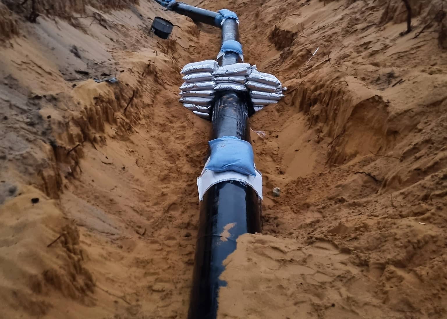 Restrained coupling on the new main in the pipe trench