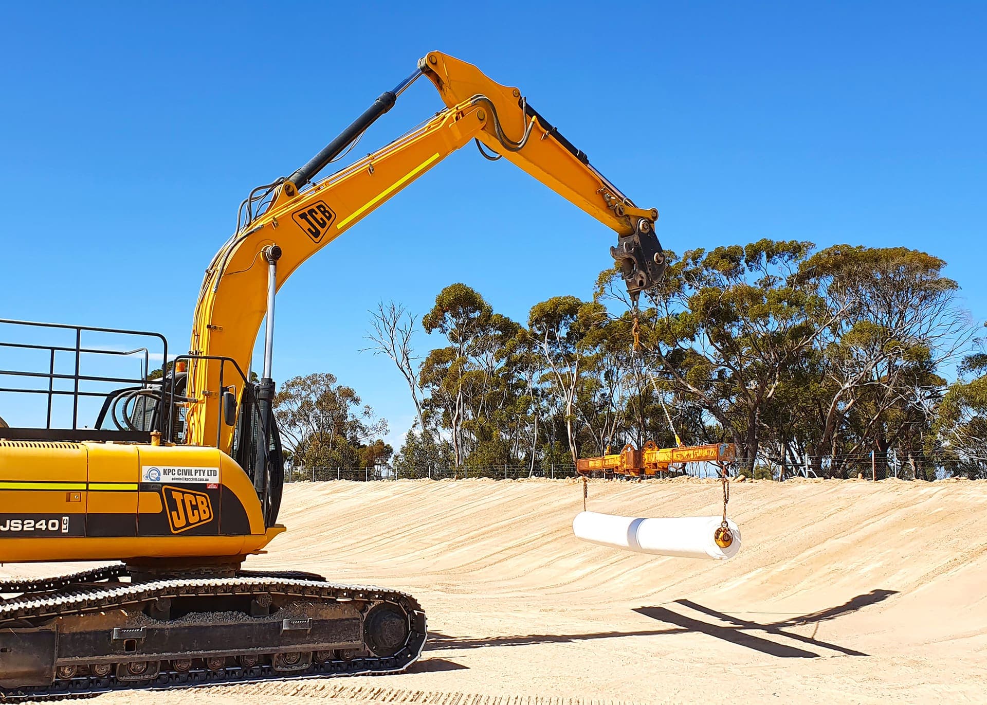 Excavator placing geofabric and blockwork across the effluent storage pond floor at Hyden