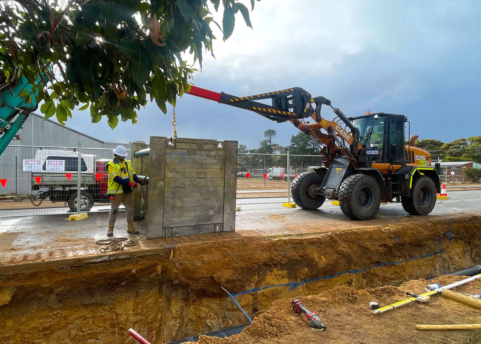 Loader placing a precast concrete valve chamber