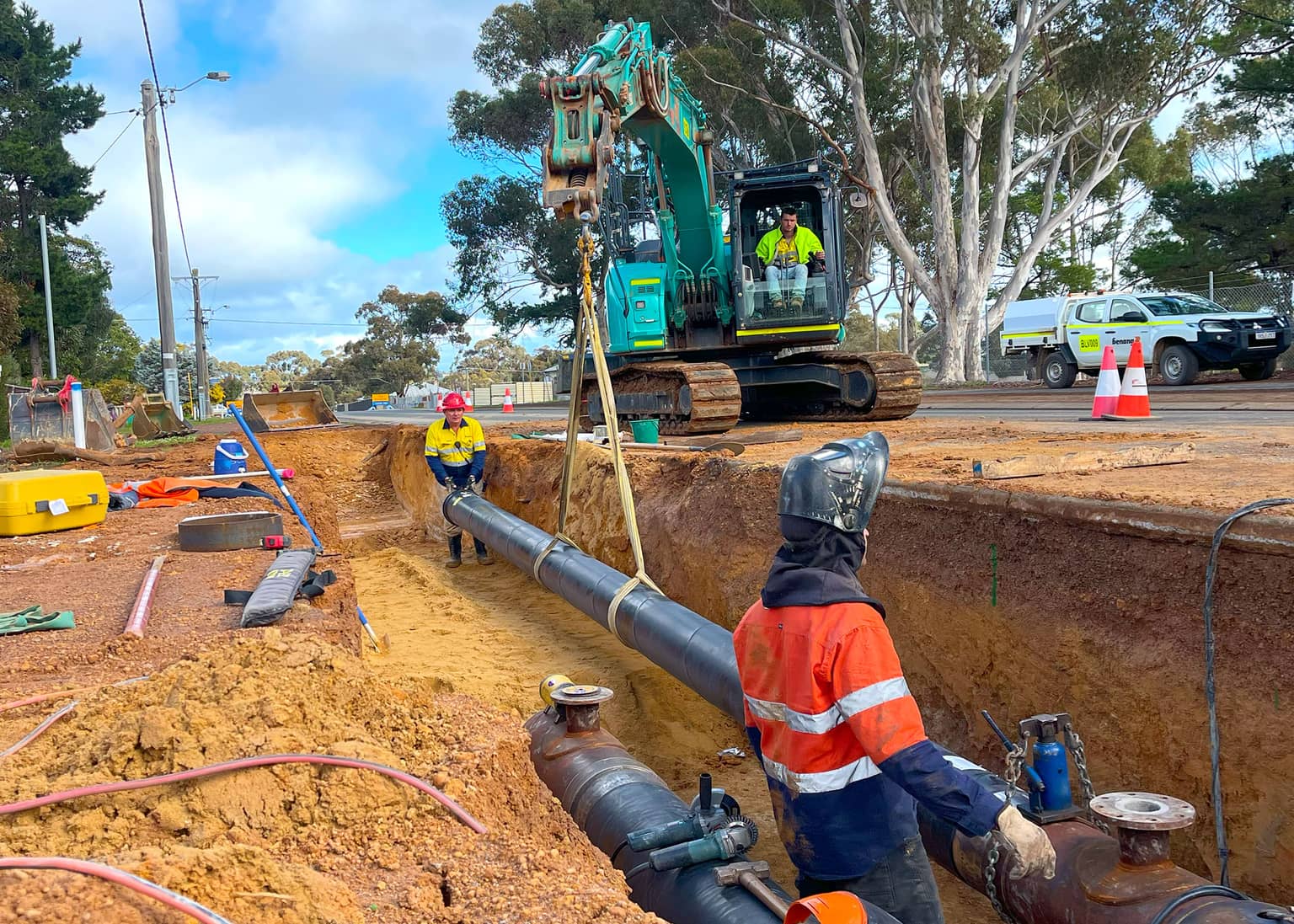 Benang crew jointing the DN300 main in the trench beneath an excavator