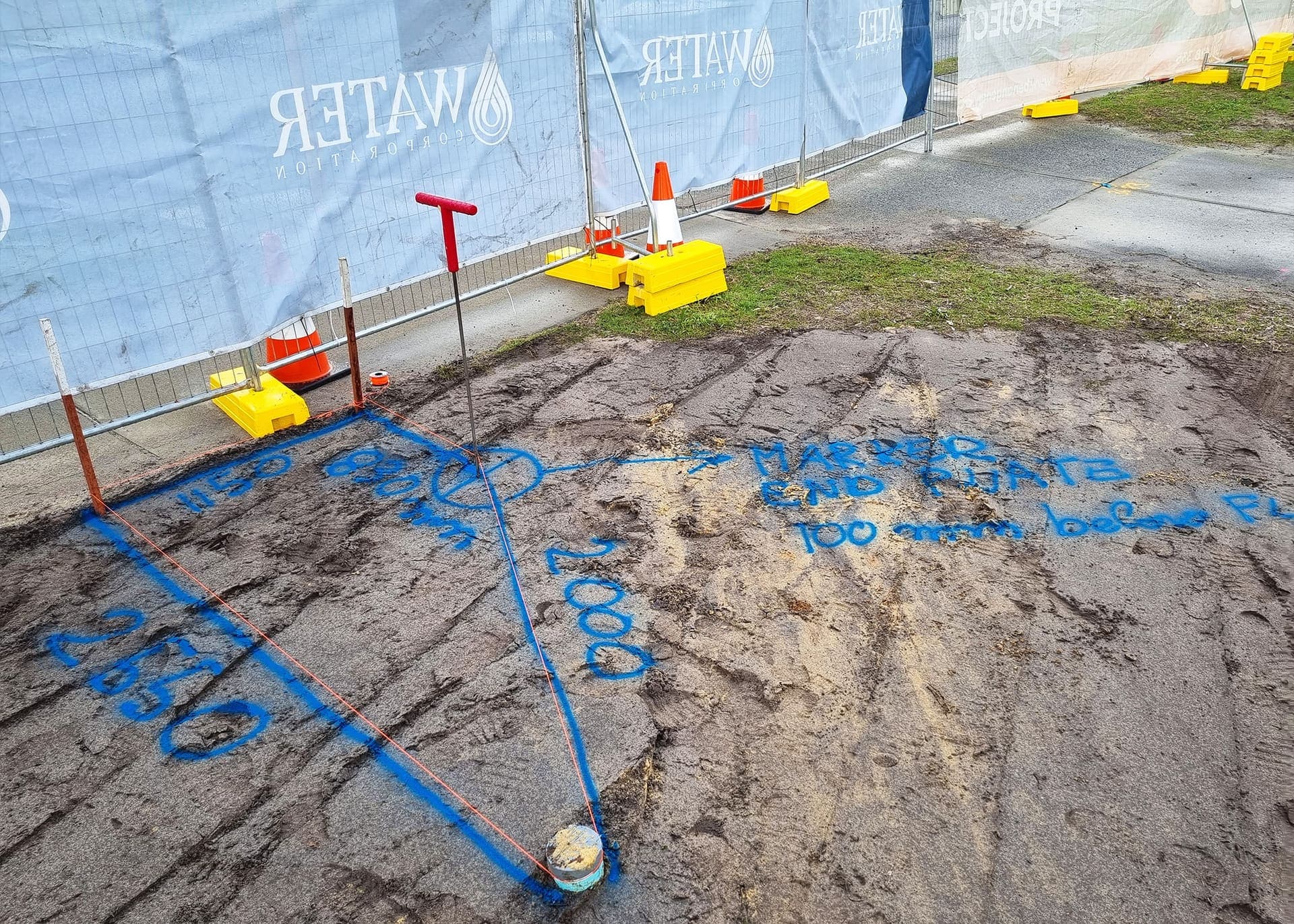 Cutover excavation set out with survey markings inside the fenced Water Corporation compound at Mirrabooka