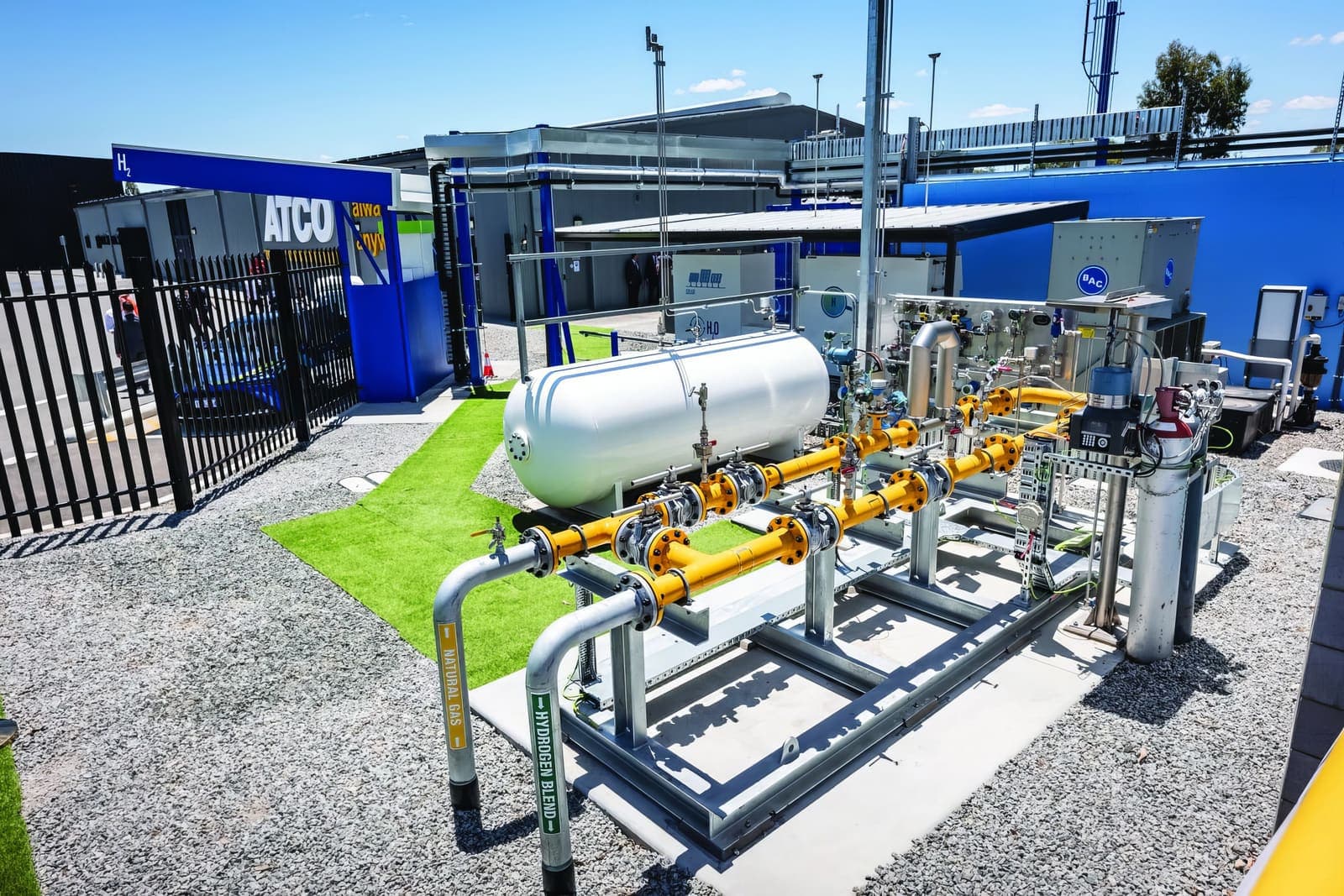 Gas blending skid with yellow pipework and pressure vessels at an ATCO facility