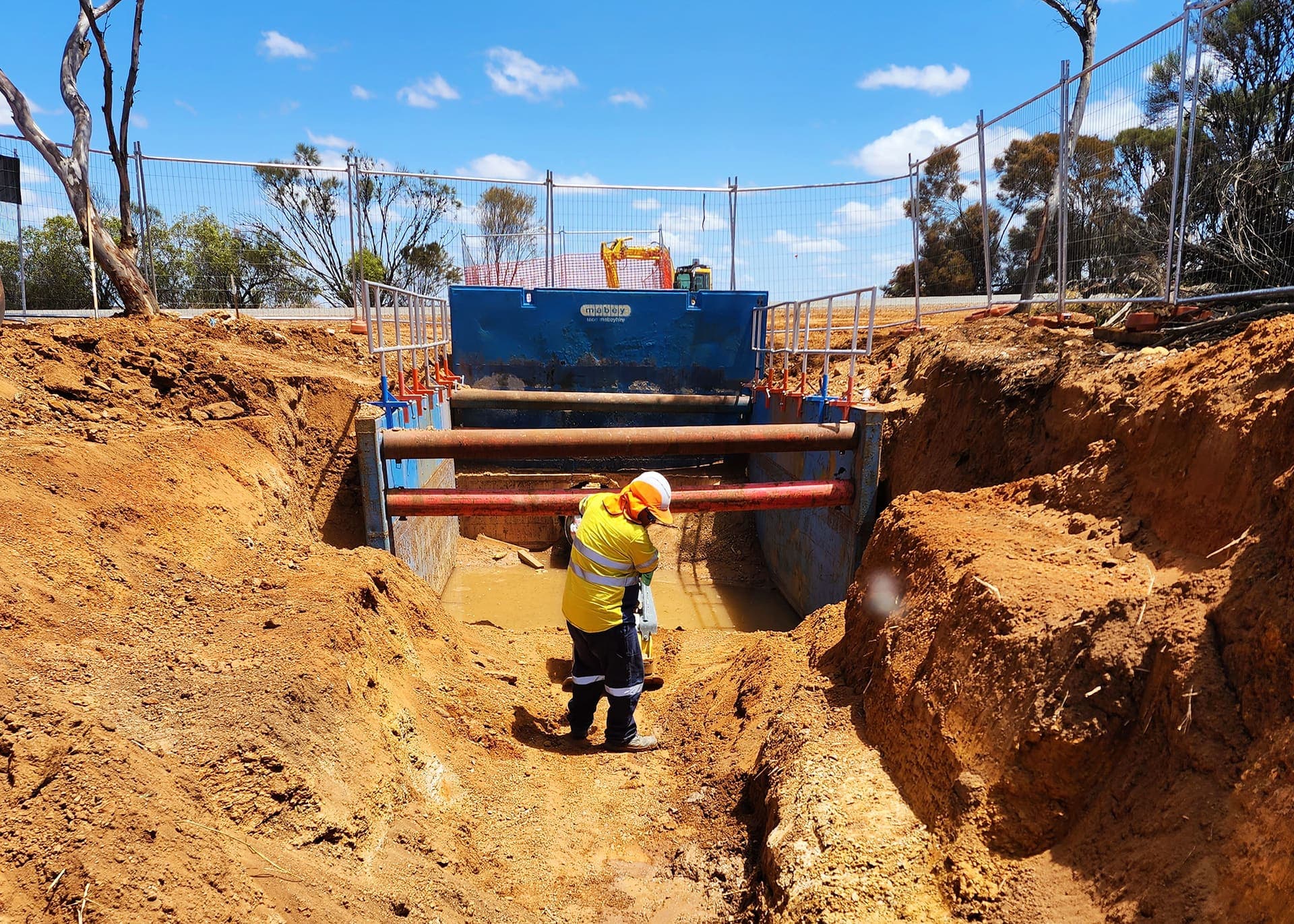 Benang worker compacting the trench inside the shoring box on the Narembeen mains replacement