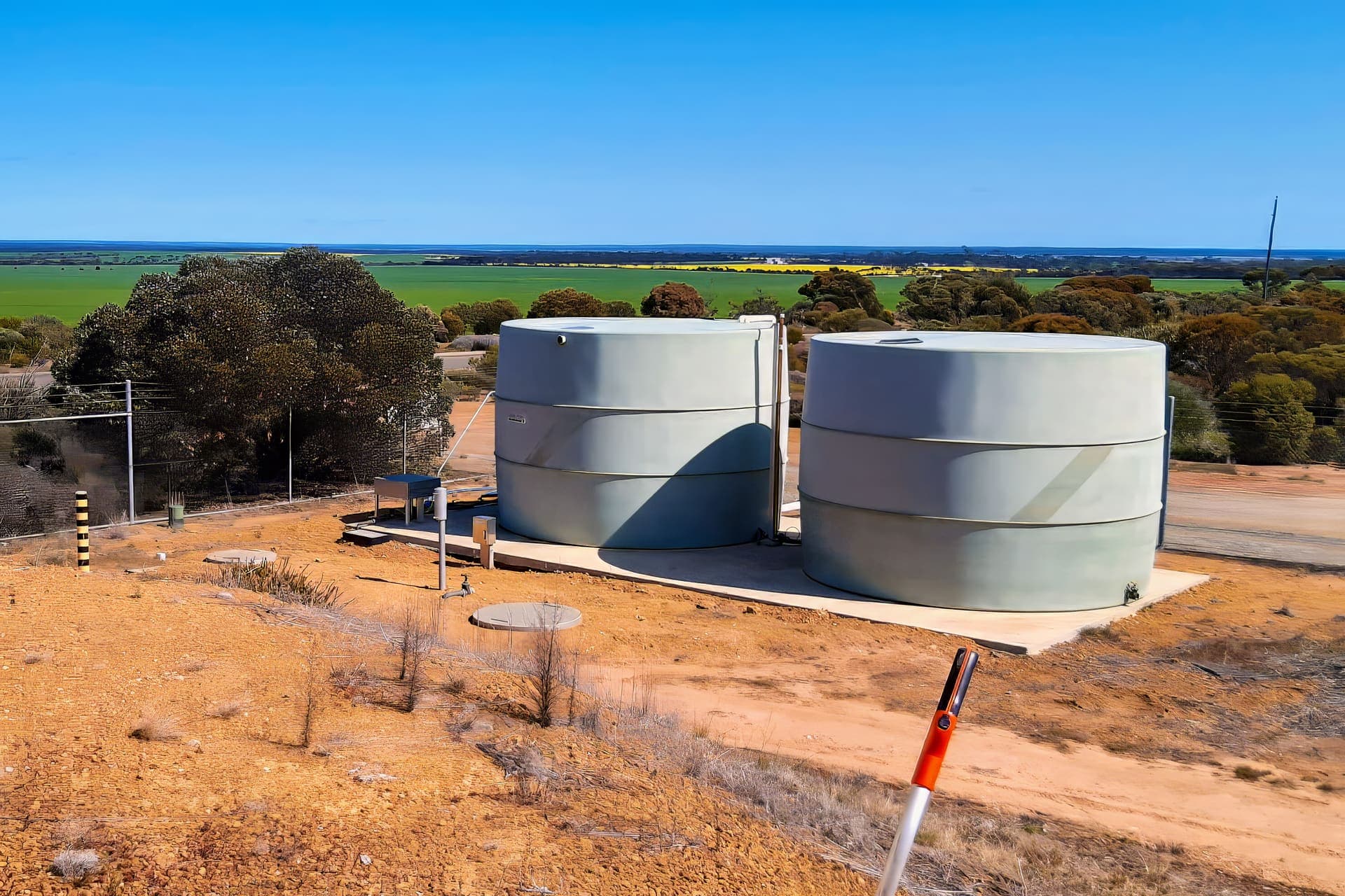 Two water storage tanks on a concrete pad above the North Lake Grace farmland