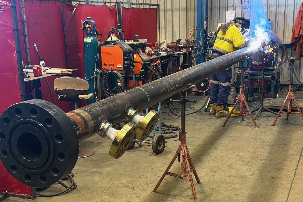 Painted carbon steel pipe spool with flanged branch ends supported on stands