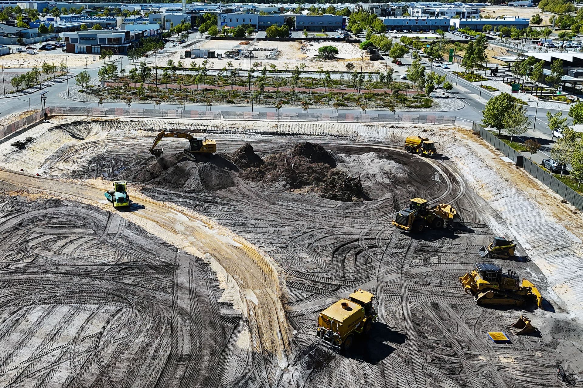 Earthworks fleet of excavator, dozers, loader, roller and water cart spread across the Lot 29 pad