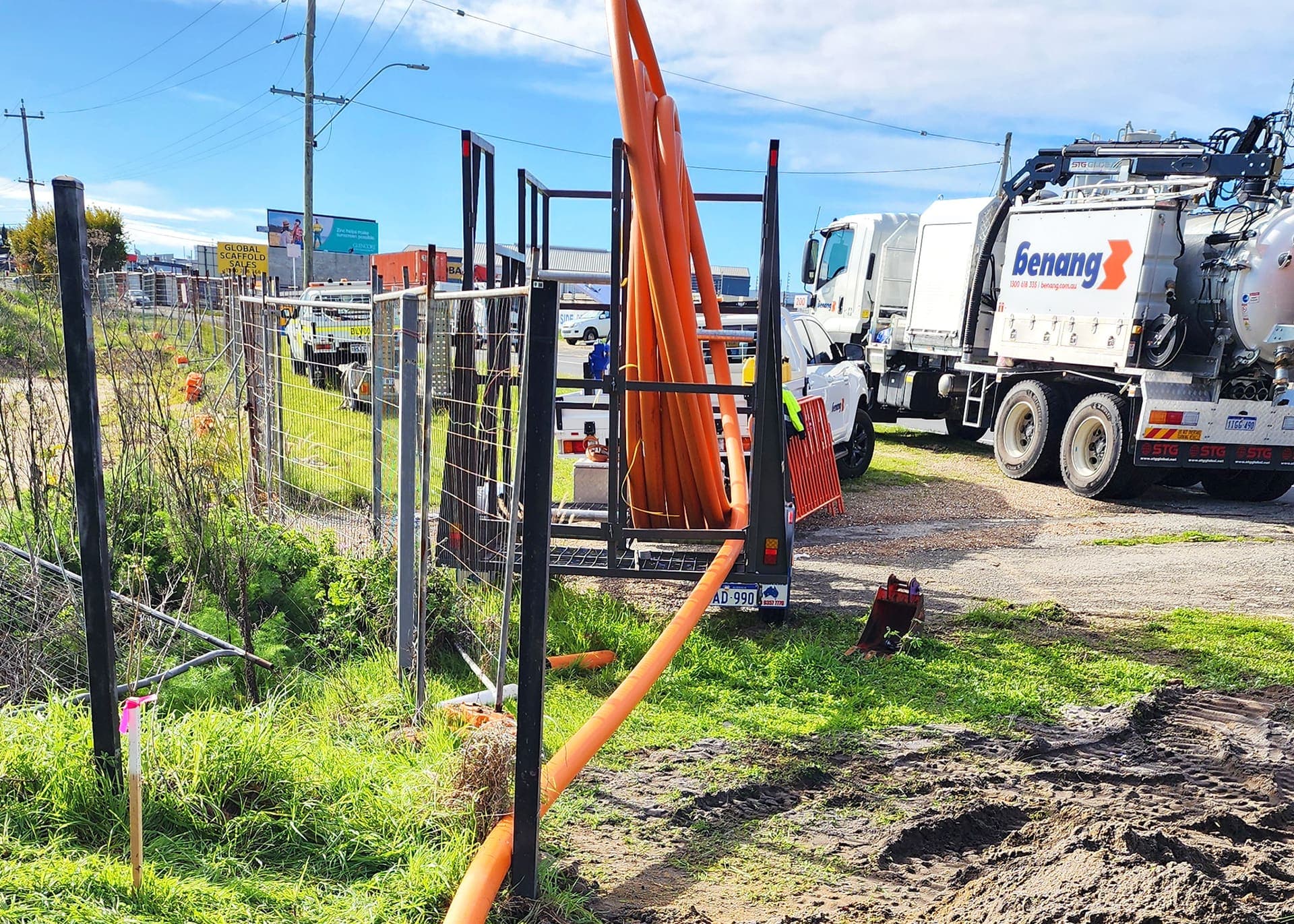 Cable drum rack loaded with orange conduit beside the Benang vac truck on the Western Power works