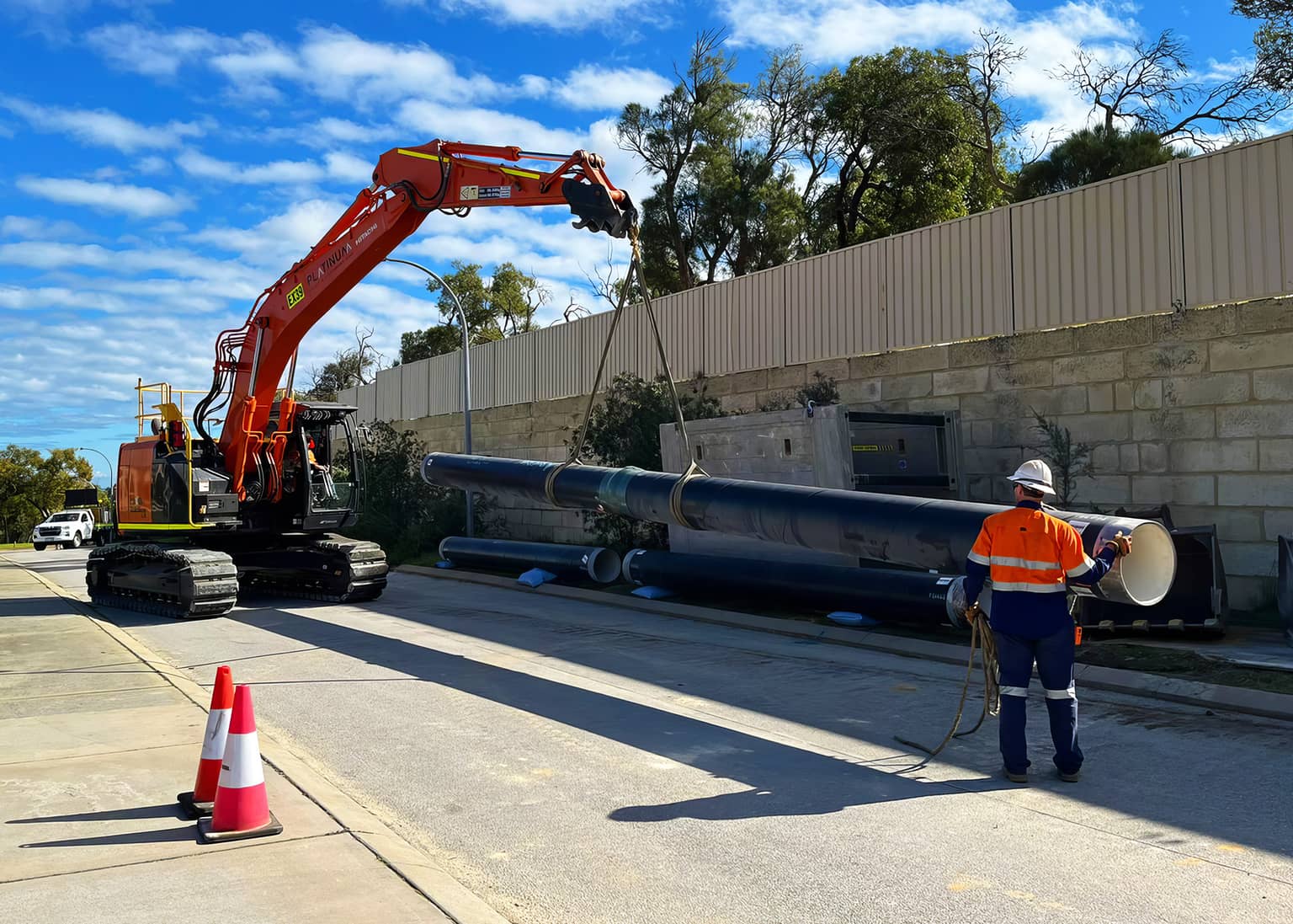 Excavator lifting a 500mm OD MSCL pipe string into position at Medina