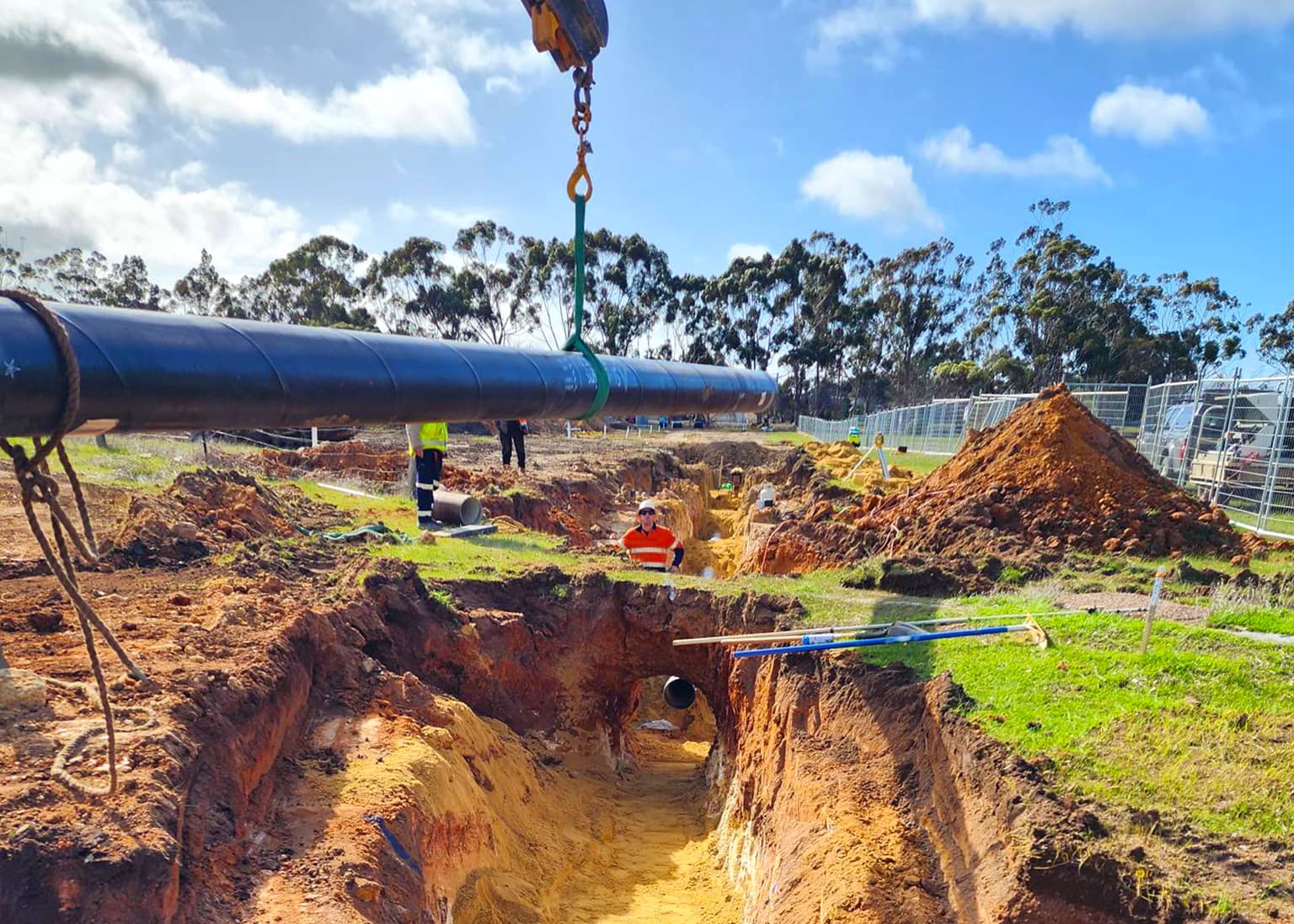 Pipe string lifted on slings over the open trench on the Kojonup to Katanning pipeline