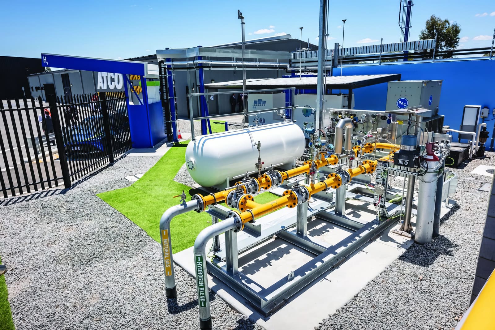 Gas blending skid with yellow pipework and pressure vessels at an ATCO facility