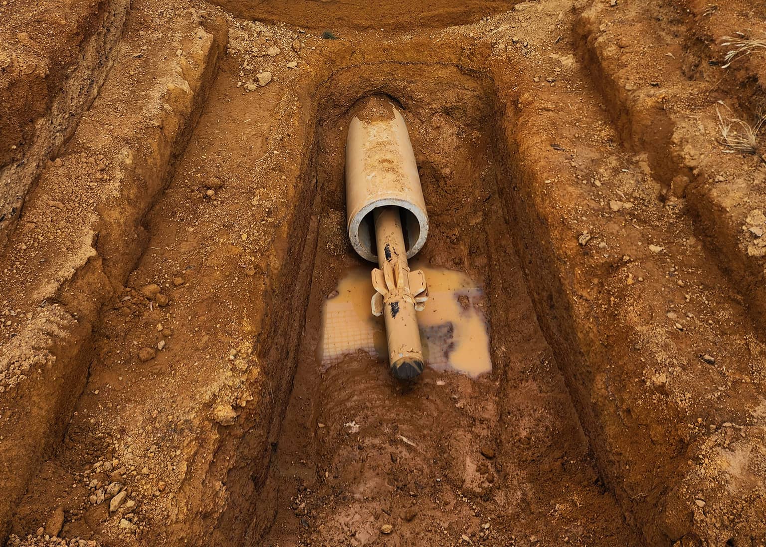 Existing main exposed and wrapped in the trench