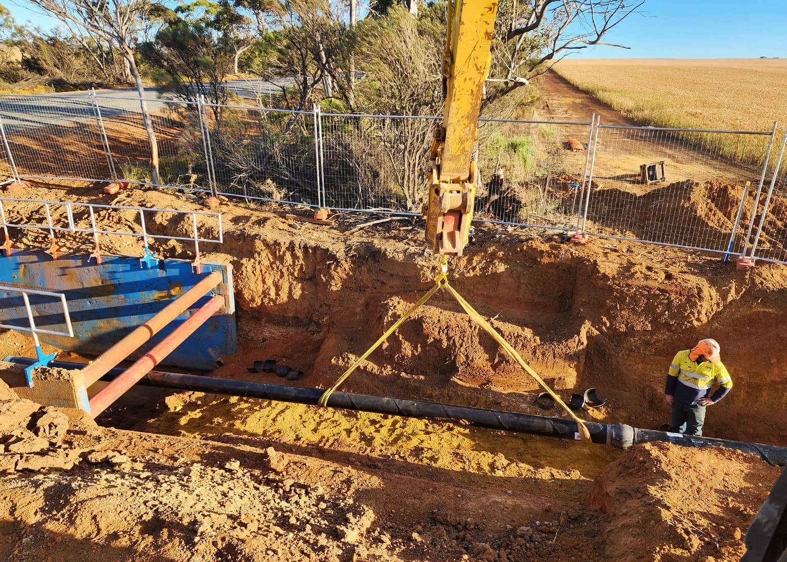 Crew lowering the new main into the trench at Narembeen