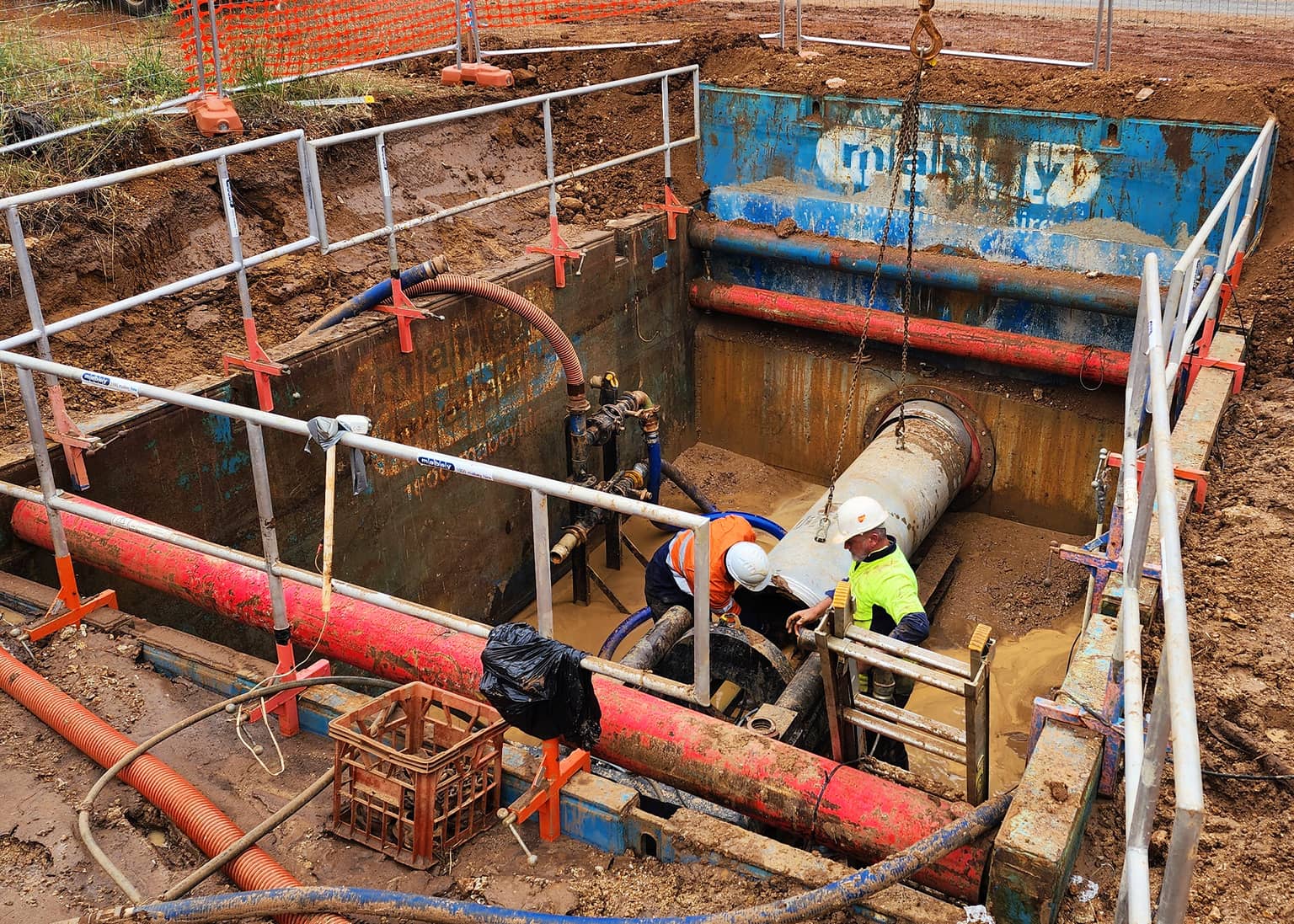 Crew jointing pipe inside the shored connection pit