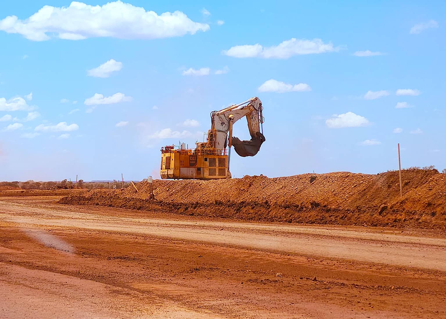 Excavator working a haul road on the Fortescue dewatering program