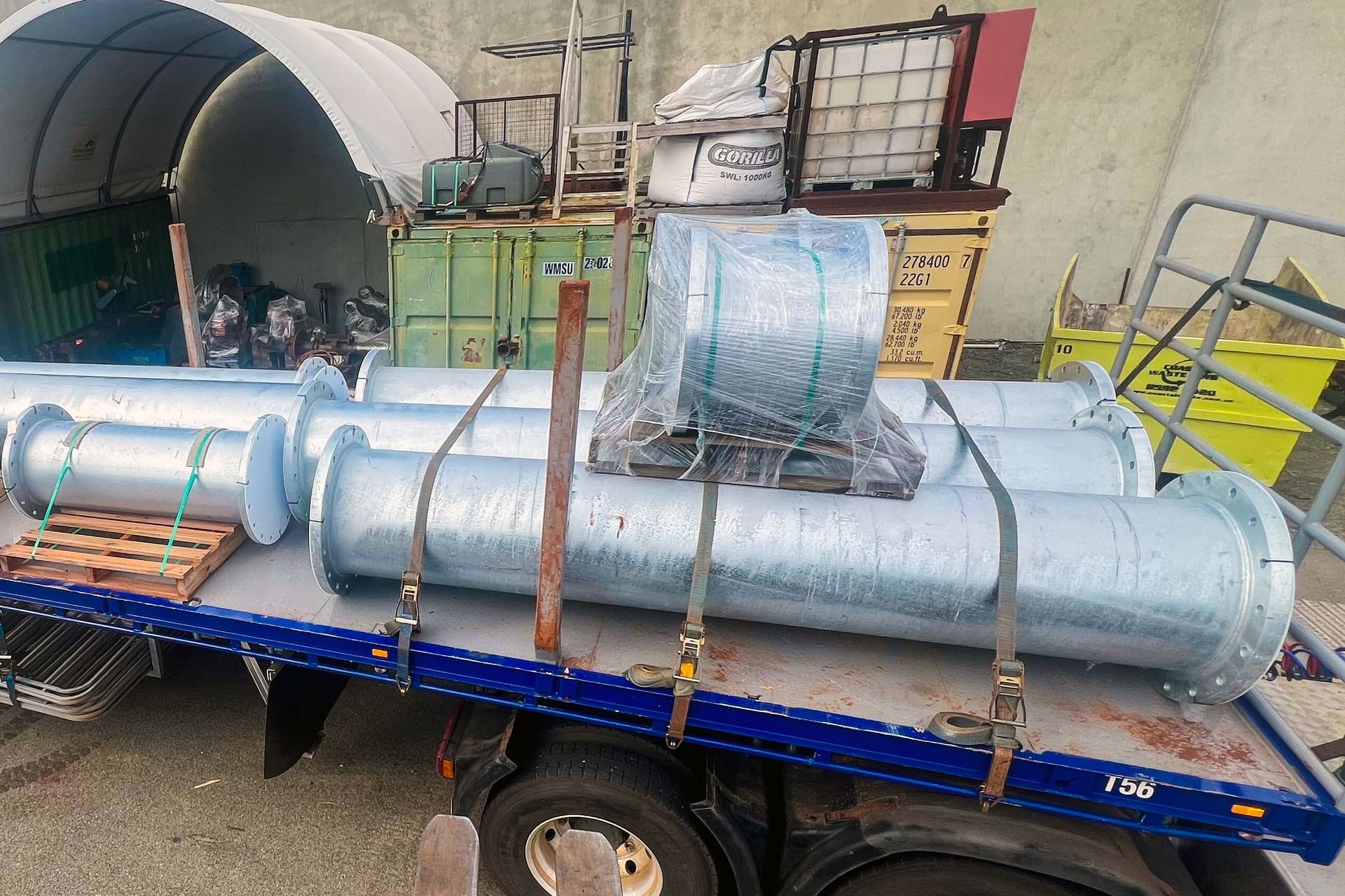 Rows of galvanised flanged pipe spools laid out across the fabrication yard