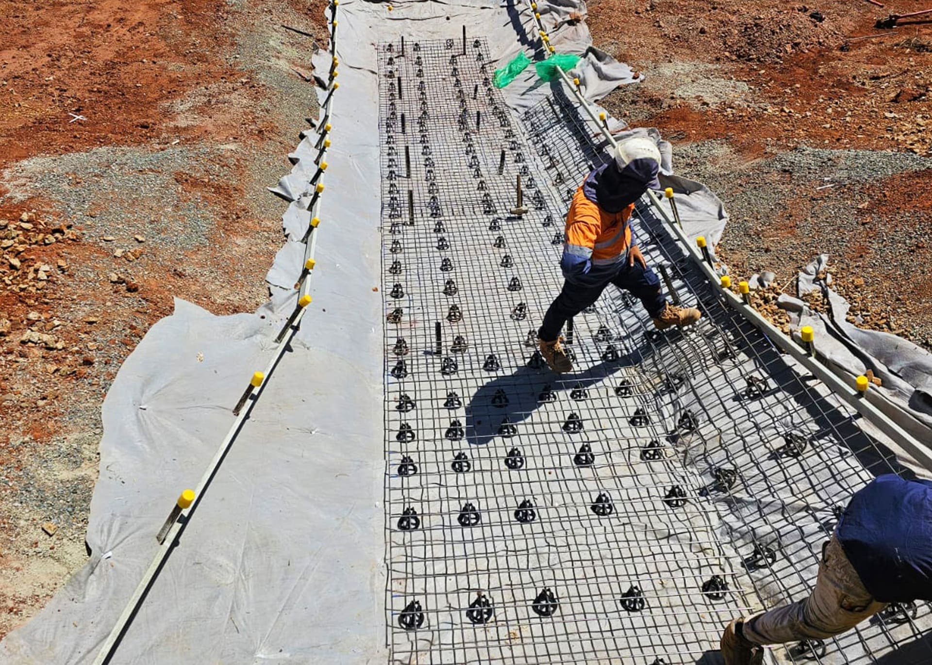 Benang crew fixing reinforcement mesh over the spillway chute ahead of shotcrete at the Kalgoorlie dam