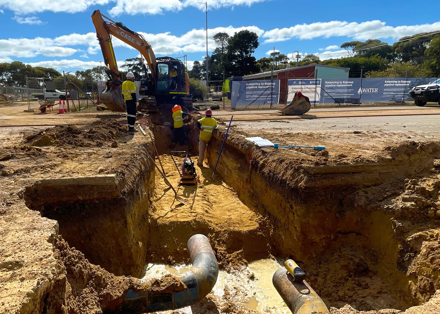 Excavator opening the connection pit around the existing main