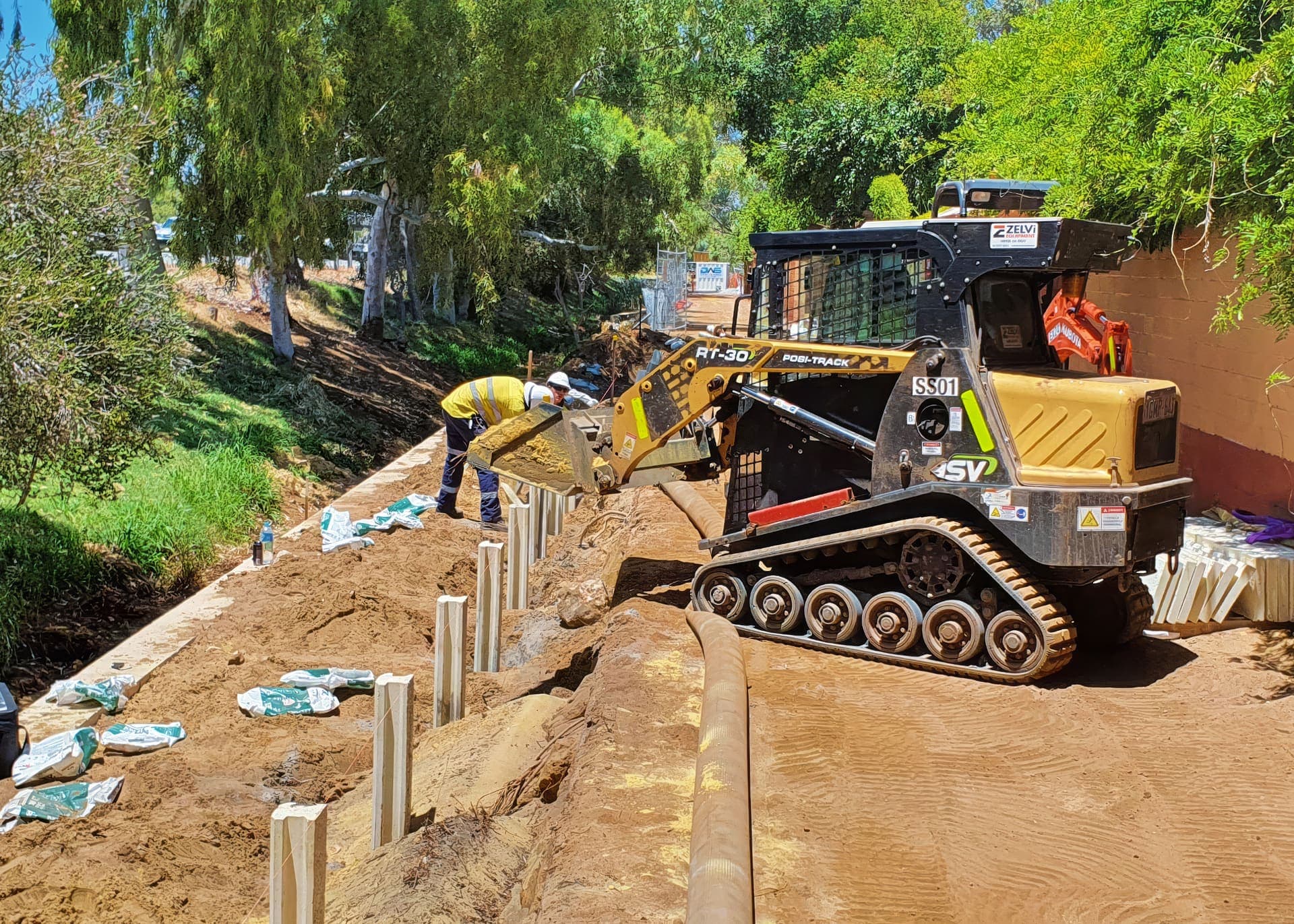 Posi-track loader backfilling behind new concrete drain support walls at Gwelup